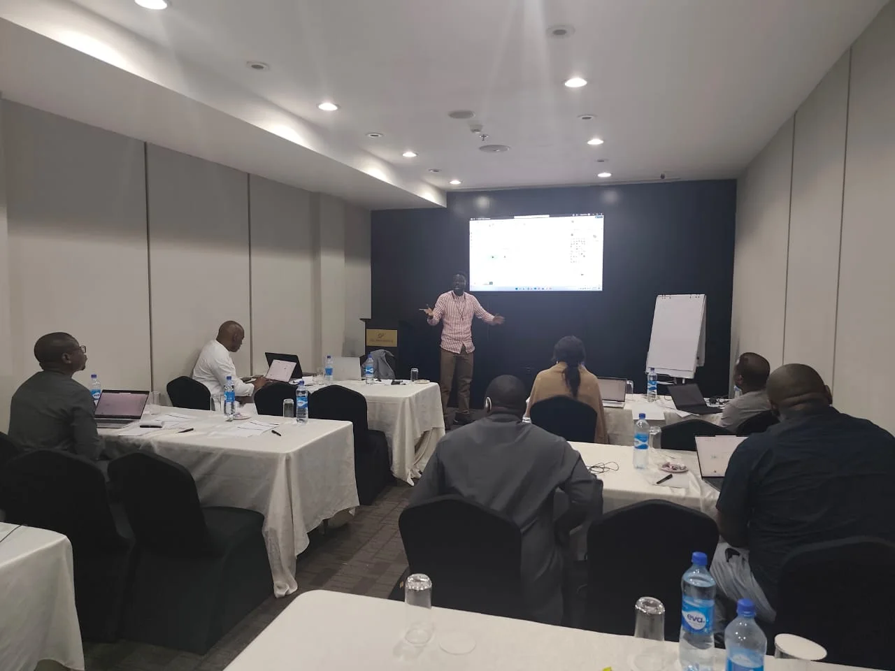 A facilitator demonstrates a software interface to participants.